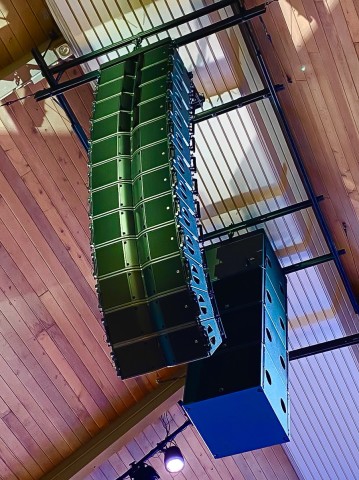 Closeup shot of auditorium speakers hanging from the ceiling.